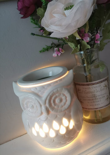white cermaic owl shaped wax burner/ aroma lamp with cut out pattern. shown lit / switched on